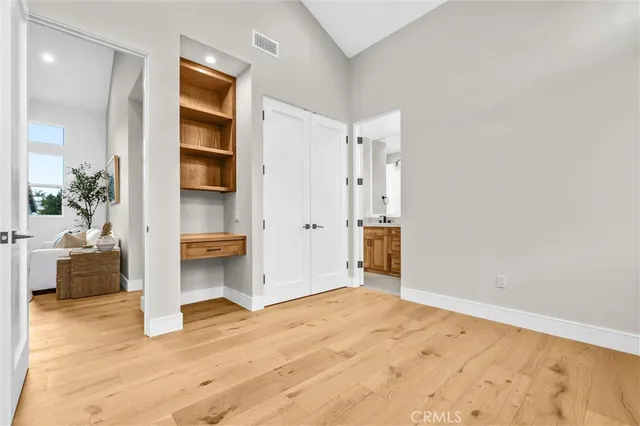 a view of empty room with wooden floor and cabinet