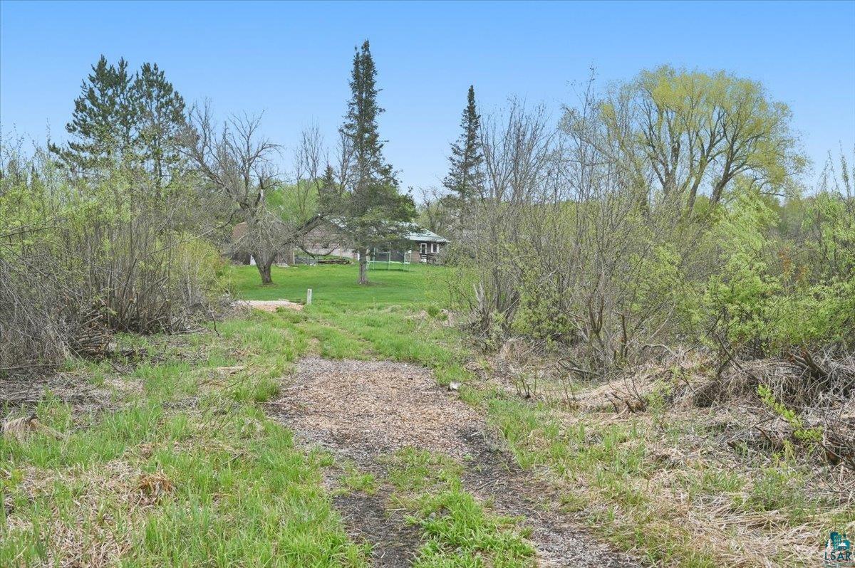 5190 County Road M Gordon, WI 54838 - Photo 26 of 31 Gravel path leading to a grassy expanse with mature trees