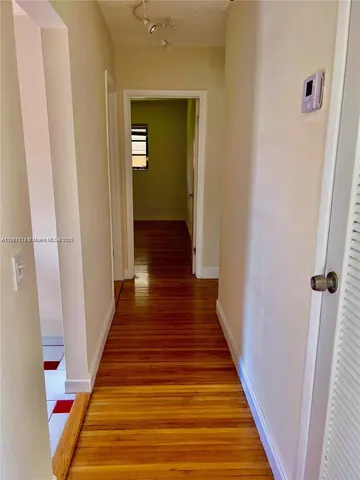 a view of a hallway with wooden floor and staircase
