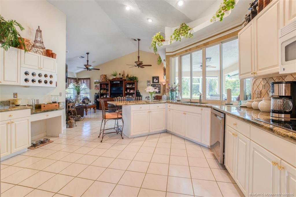 1171 Southeast Buttonwood Circle Stuart, FL 34997 - Photo 12 of 36 a large white kitchen with lots of counter top and appliances
