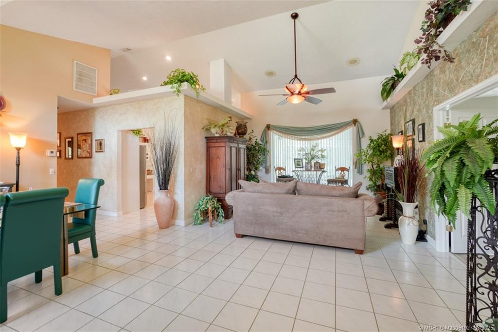 1171 Southeast Buttonwood Circle Stuart, FL 34997 - Photo 19 of 36 a living room with furniture a chandelier and a fireplace