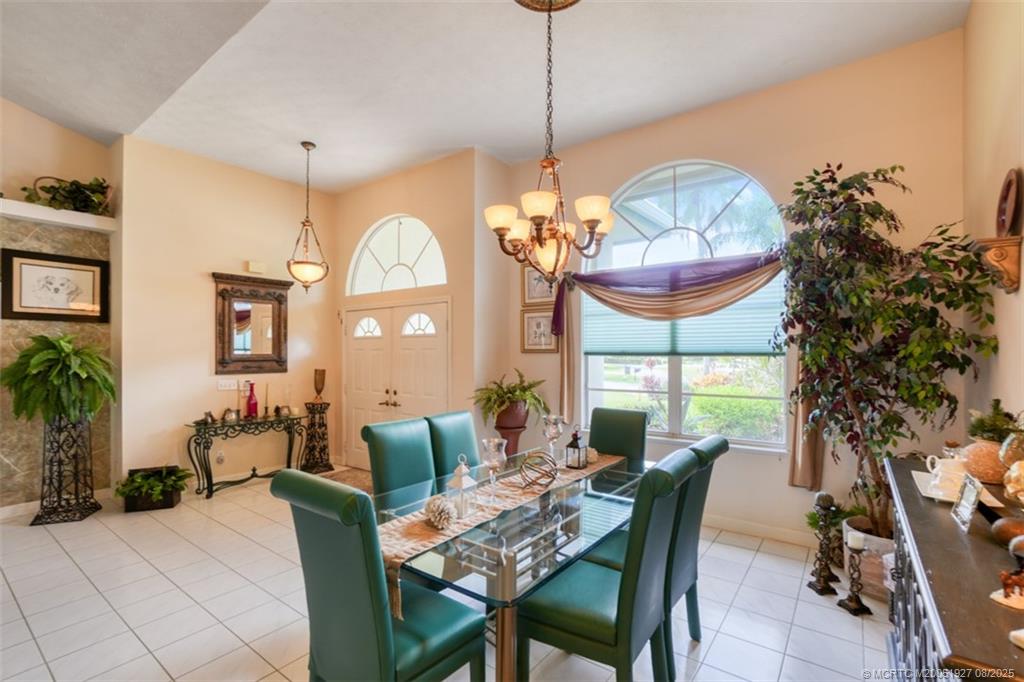 1171 Southeast Buttonwood Circle Stuart, FL 34997 - Photo 23 of 36 a dining room with furniture a chandelier and a rug