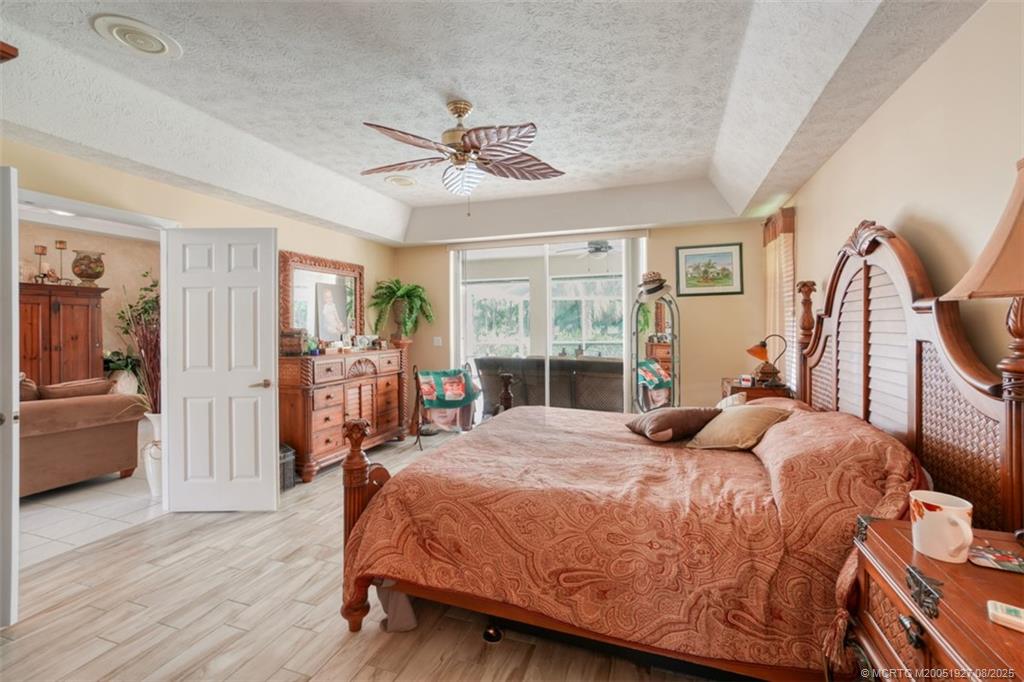 1171 Southeast Buttonwood Circle Stuart, FL 34997 - Photo 24 of 36 a bedroom with a bed and wooden floor