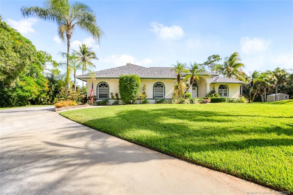 1171 Southeast Buttonwood Circle Stuart, FL 34997 - Photo 3 of 36 a front view of house with yard and green space