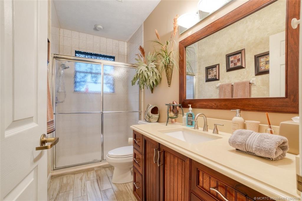 1171 Southeast Buttonwood Circle Stuart, FL 34997 - Photo 31 of 36 a bathroom with a sink a toilet and shower
