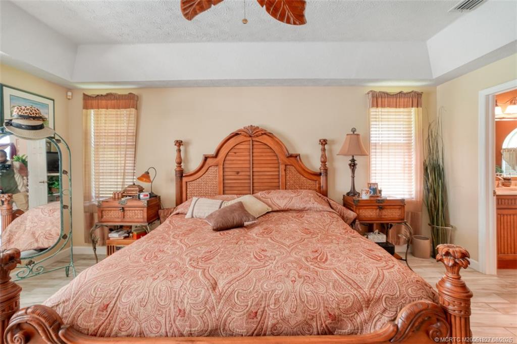 1171 Southeast Buttonwood Circle Stuart, FL 34997 - Photo 32 of 36 a bedroom with a bed and a large window