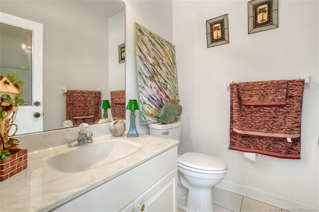 1171 Southeast Buttonwood Circle Stuart, FL 34997 - Photo 33 of 36 a bathroom with a sink a toilet and mirror