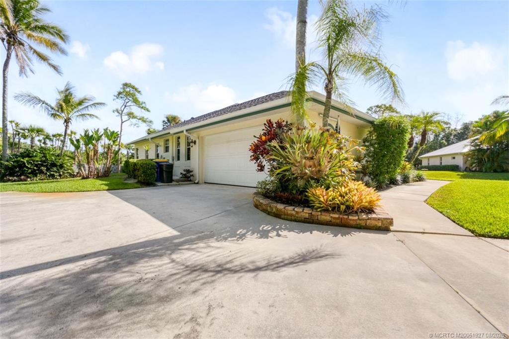 1171 Southeast Buttonwood Circle Stuart, FL 34997 - Photo 5 of 36 a view of a house with a yard and palm trees
