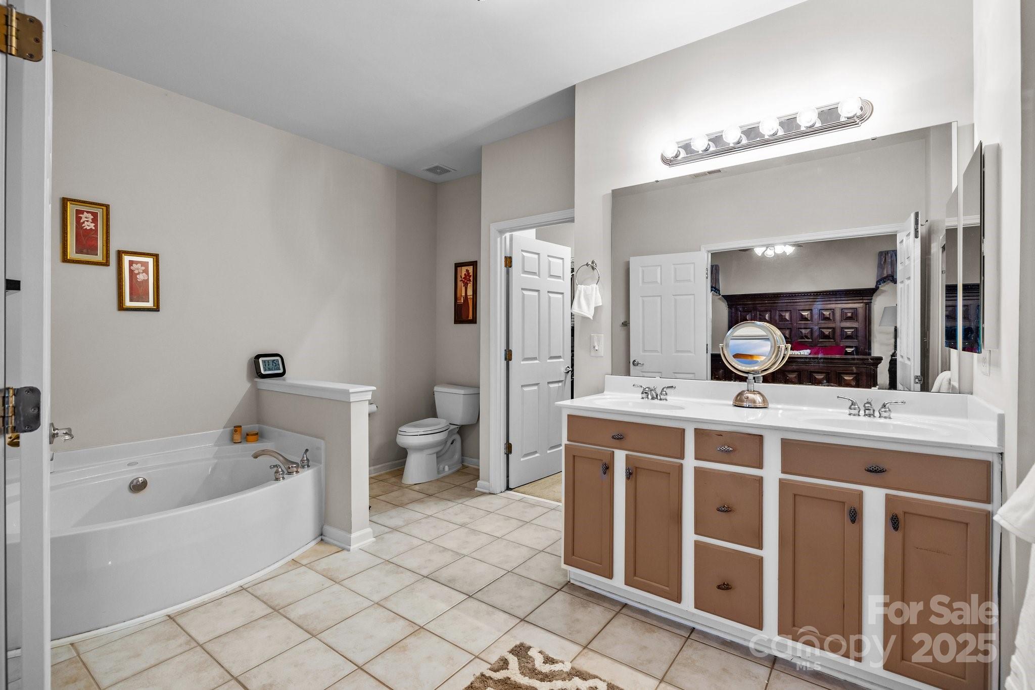 1668 Onyx Ridge, Unit 116 Fort Mill, SC 29708 - Photo 12 of 20 a spacious bathroom with a double vanity sink mirror and bathtub