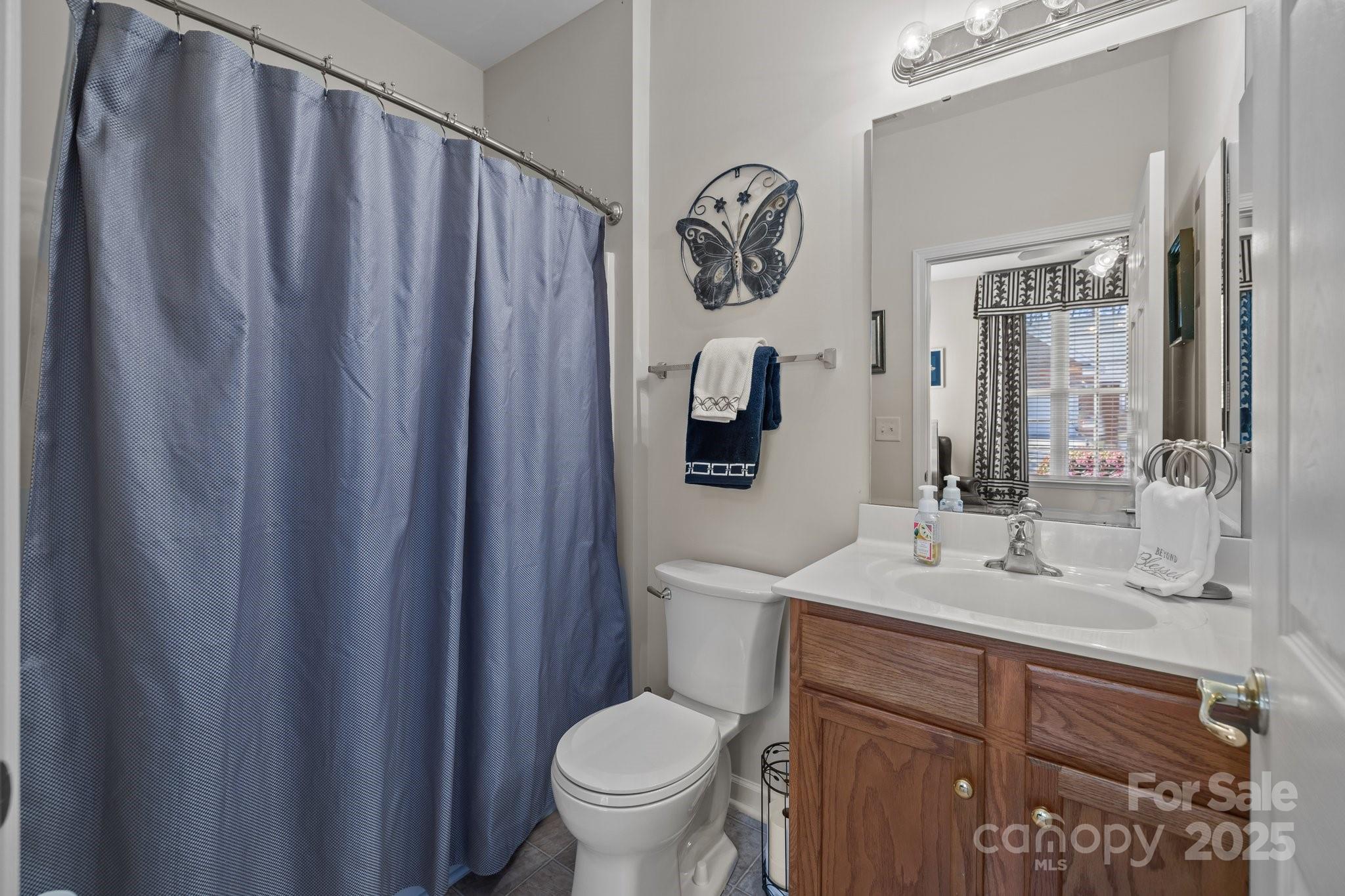 1668 Onyx Ridge, Unit 116 Fort Mill, SC 29708 - Photo 15 of 20 a bathroom with a toilet a sink and a mirror