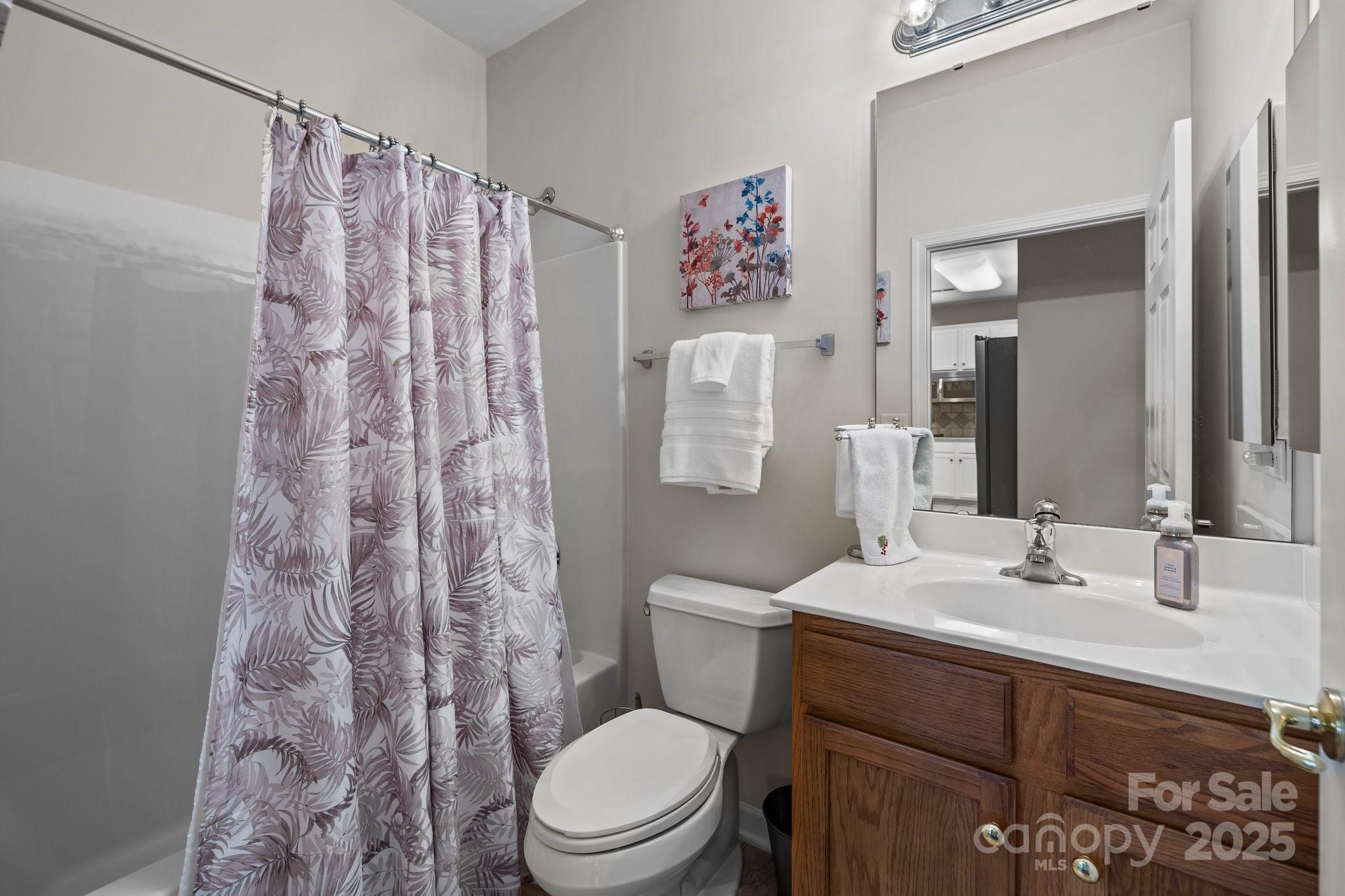 1668 Onyx Ridge, Unit 116 Fort Mill, SC 29708 - Photo 17 of 20 a bathroom with a sink a toilet and shower curtain