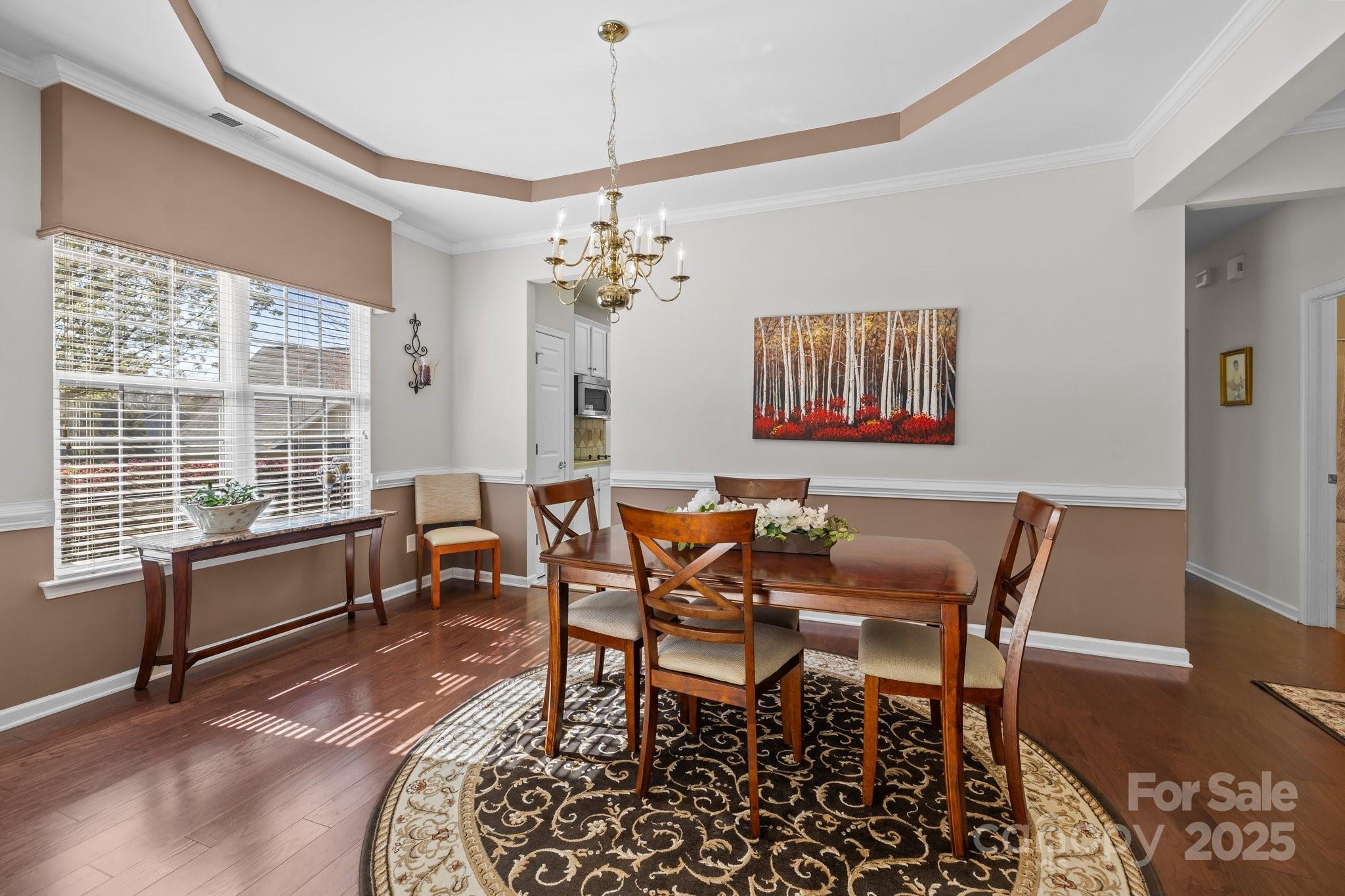 1668 Onyx Ridge, Unit 116 Fort Mill, SC 29708 - Photo 3 of 20 a dining room with furniture a chandelier and wooden floor