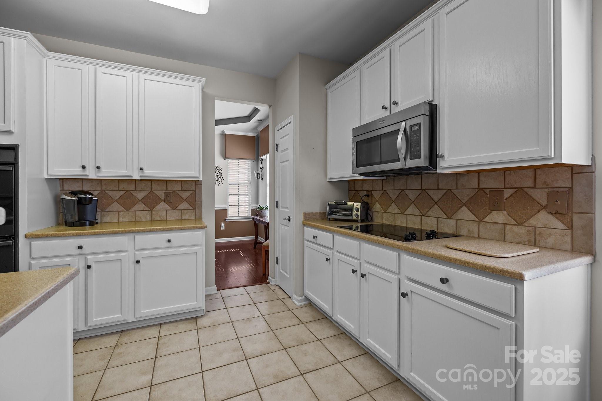 1668 Onyx Ridge, Unit 116 Fort Mill, SC 29708 - Photo 7 of 20 a kitchen with granite countertop white cabinets stainless steel appliances with a sink and dishwasher