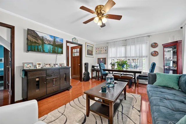 a living room with furniture a flat screen tv and kitchen view