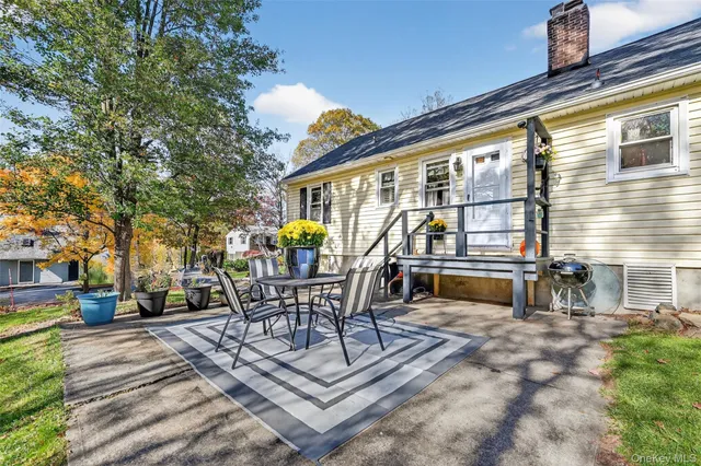 a view of a patio with table and chairs with wooden floor and fence