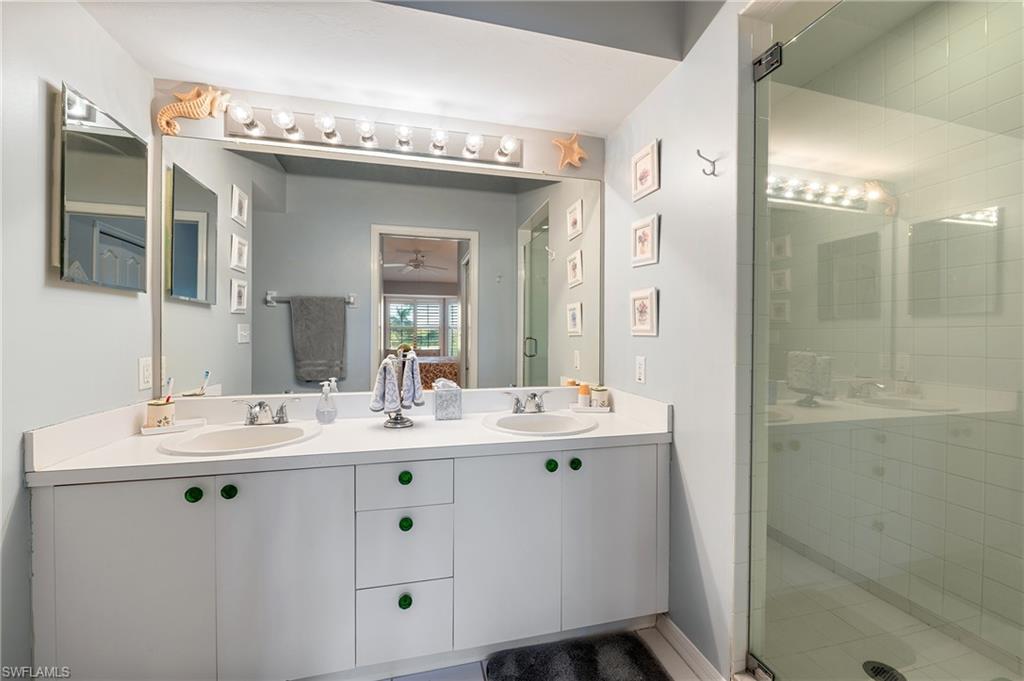 26991 Clarkston Drive, Unit 8202 Bonita Springs, FL 34135 - Photo 17 of 20 a bathroom with a double vanity sink mirror and shower