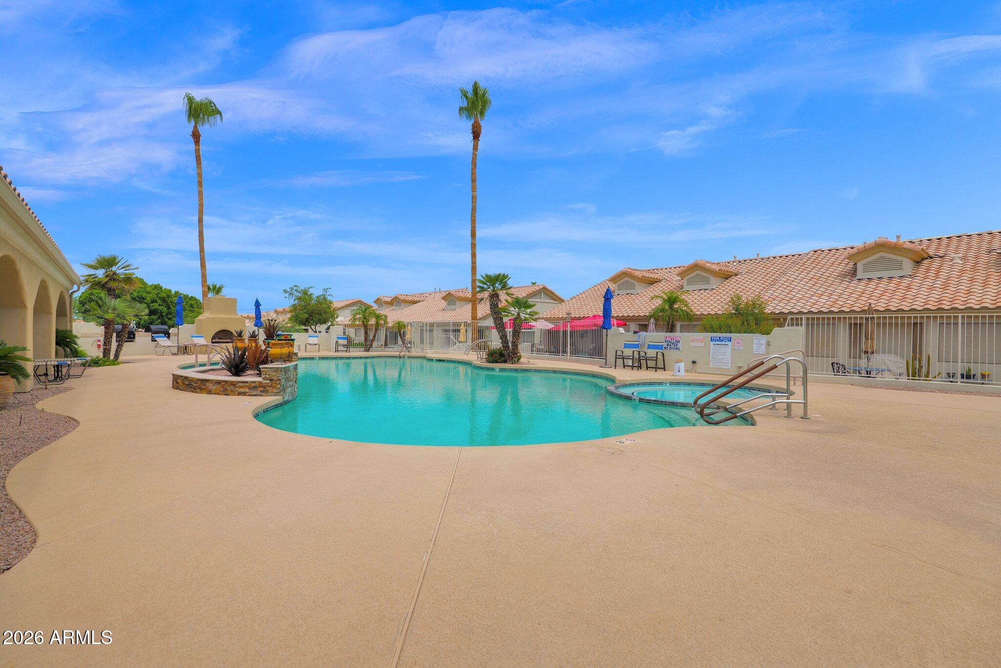 5830 East McKellips Road, Unit 110 Mesa, AZ 85215 - Photo 38 of 45 a view of a swimming pool with a table and chairs