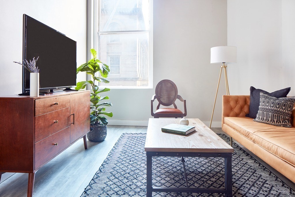 630 Washington Street, Unit 407 Boston, MA 02111 - Photo 11 of 11 a living room with furniture and a flat screen tv