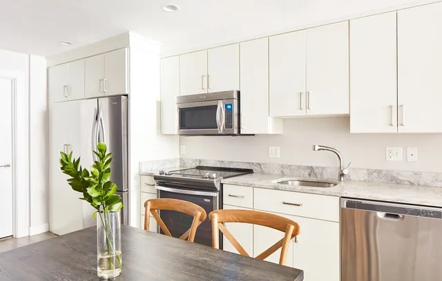 a kitchen with stainless steel appliances granite countertop a refrigerator a stove a sink a microwave and cabinets