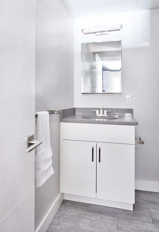 630 Washington Street, Unit 407 Boston, MA 02111 - Photo 4 of 11 a bathroom with a sink a vanity and a mirror
