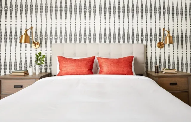 a large white bed sitting in a bedroom next to a window