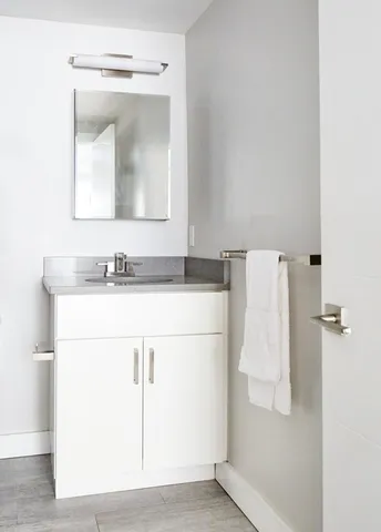 a bathroom with a sink vanity and a mirror