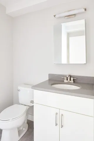 a bathroom with a sink a toilet and mirror
