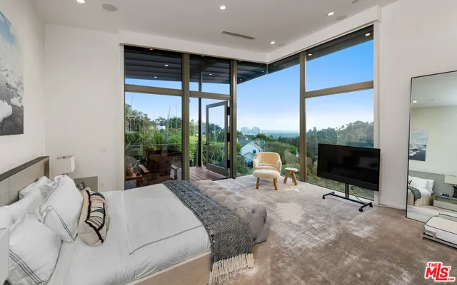 a bedroom with furniture and a large window