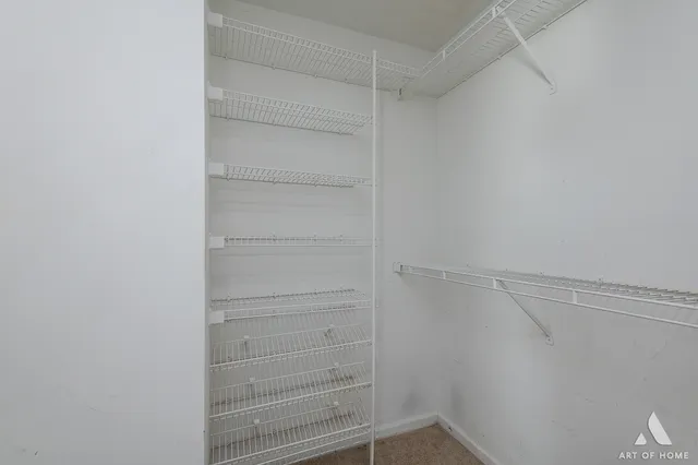 a view of walk in closet with empty racks
