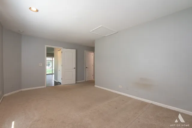 a view of an empty room with window and closet area