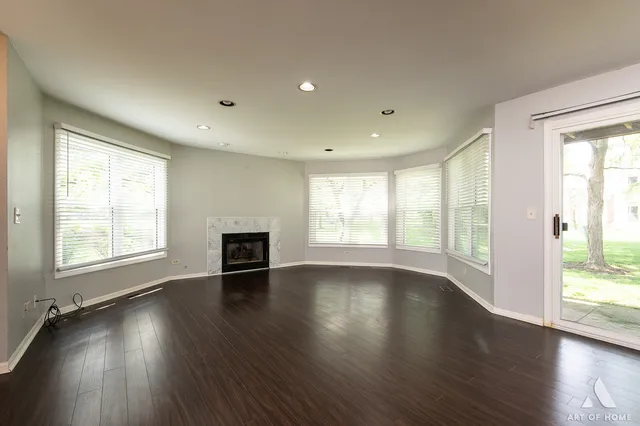 an empty room with wooden floor and a fireplace