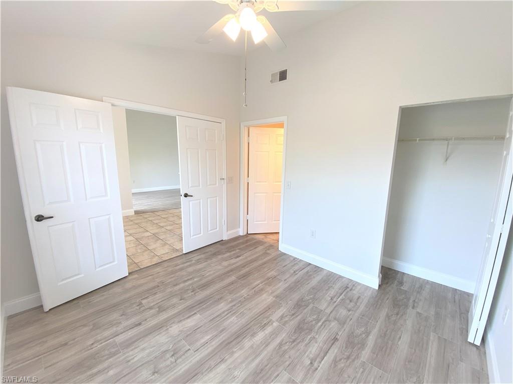 7965 Preserve Circle, Unit 734 Naples, FL 34119 - Photo 14 of 20 an empty room with wooden floor and windows