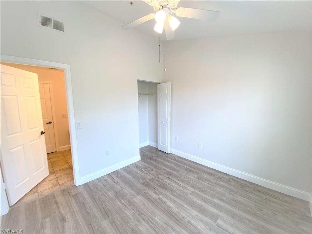 7965 Preserve Circle, Unit 734 Naples, FL 34119 - Photo 15 of 20 an empty room with wooden floor and windows