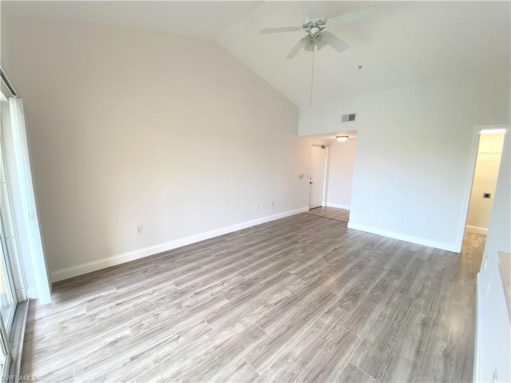 7965 Preserve Circle, Unit 734 Naples, FL 34119 - Photo 3 of 20 a view of empty room with wooden floor and ceiling fan