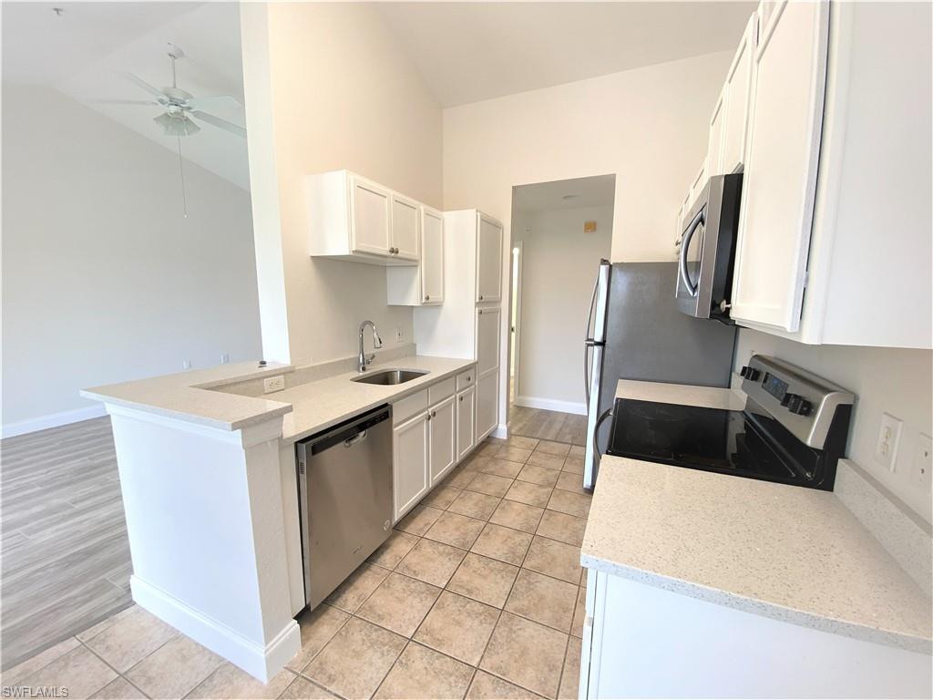 7965 Preserve Circle, Unit 734 Naples, FL 34119 - Photo 7 of 20 a kitchen with a sink a stove and refrigerator