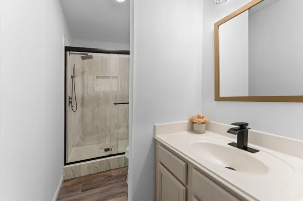 a bathroom with a shower sink and mirror