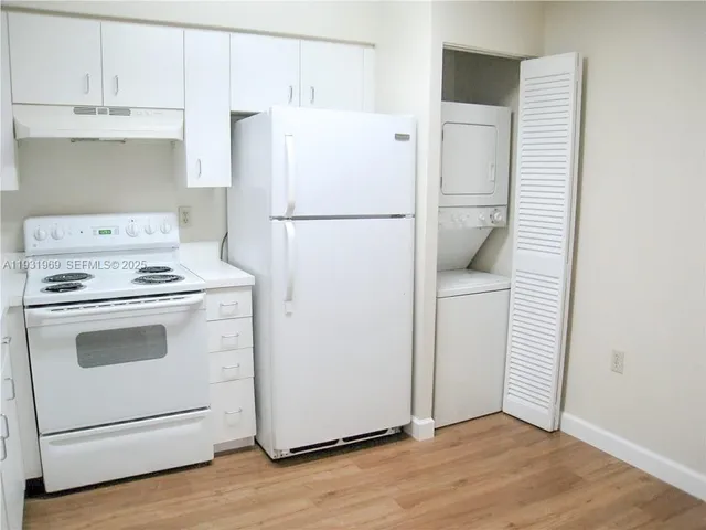 a white refrigerator freezer and a stove sitting inside of a kitchen