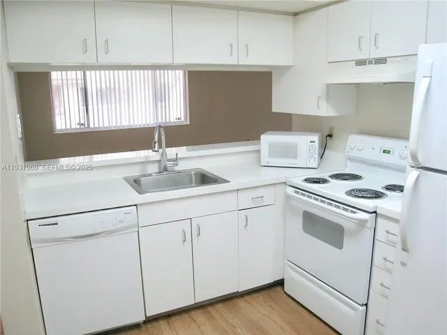 a kitchen with stainless steel appliances white cabinets and a sink