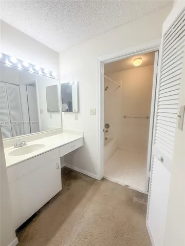 a bathroom with a tub sink and mirror