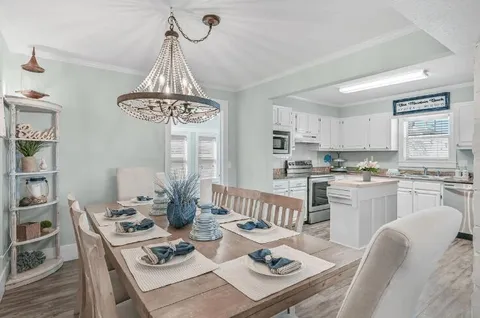 a kitchen with stainless steel appliances granite countertop a dining table chairs a stove a microwave a dining table and chairs