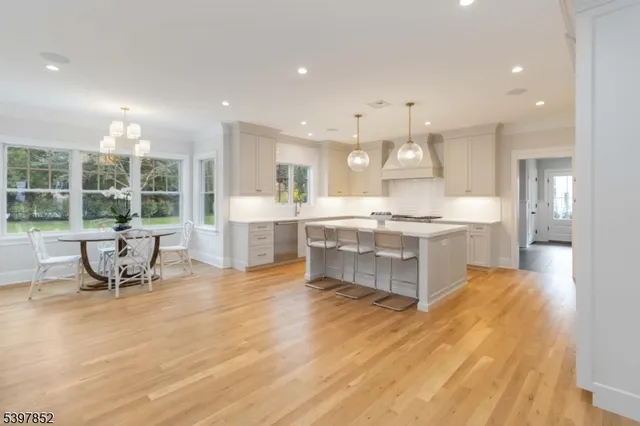 a dining hall with stainless steel appliances kitchen island granite countertop a stove and a sink