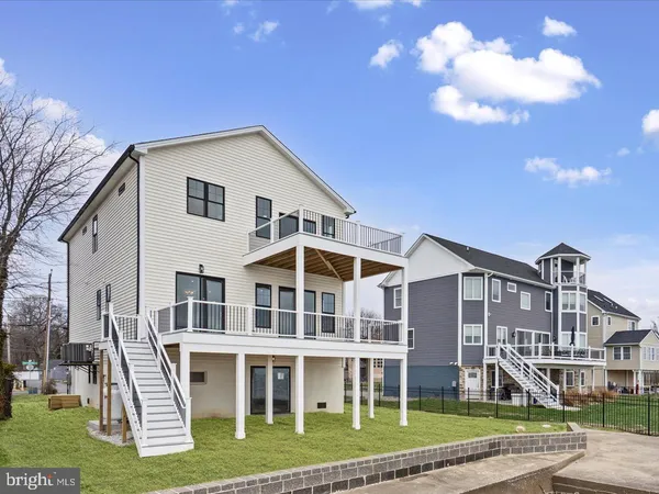 a large kitchen with stainless steel appliances granite countertop a sink dishwasher a stove and a large refrigerator with wooden floor