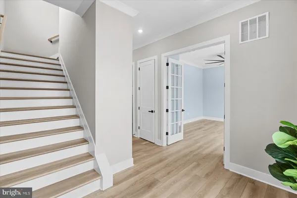 a view of empty room with wooden floor and fan