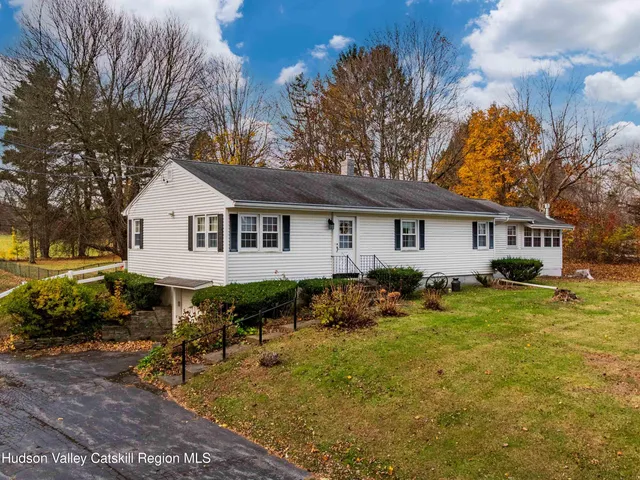 a view of a house with backyard and sitting area
