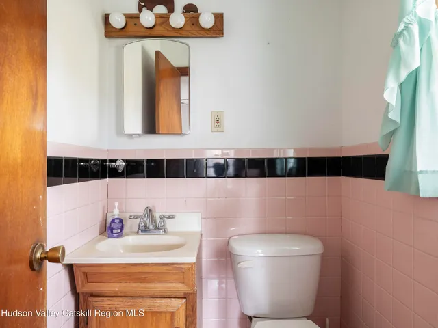 a bathroom with a sink a toilet and a mirror