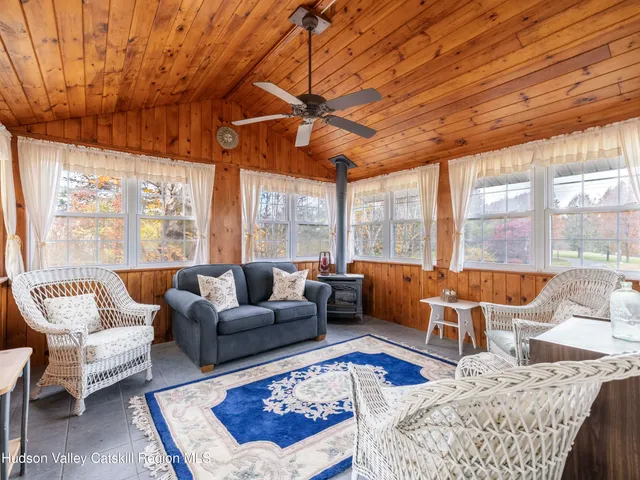 a living room with furniture a rug wooden floor and a large window