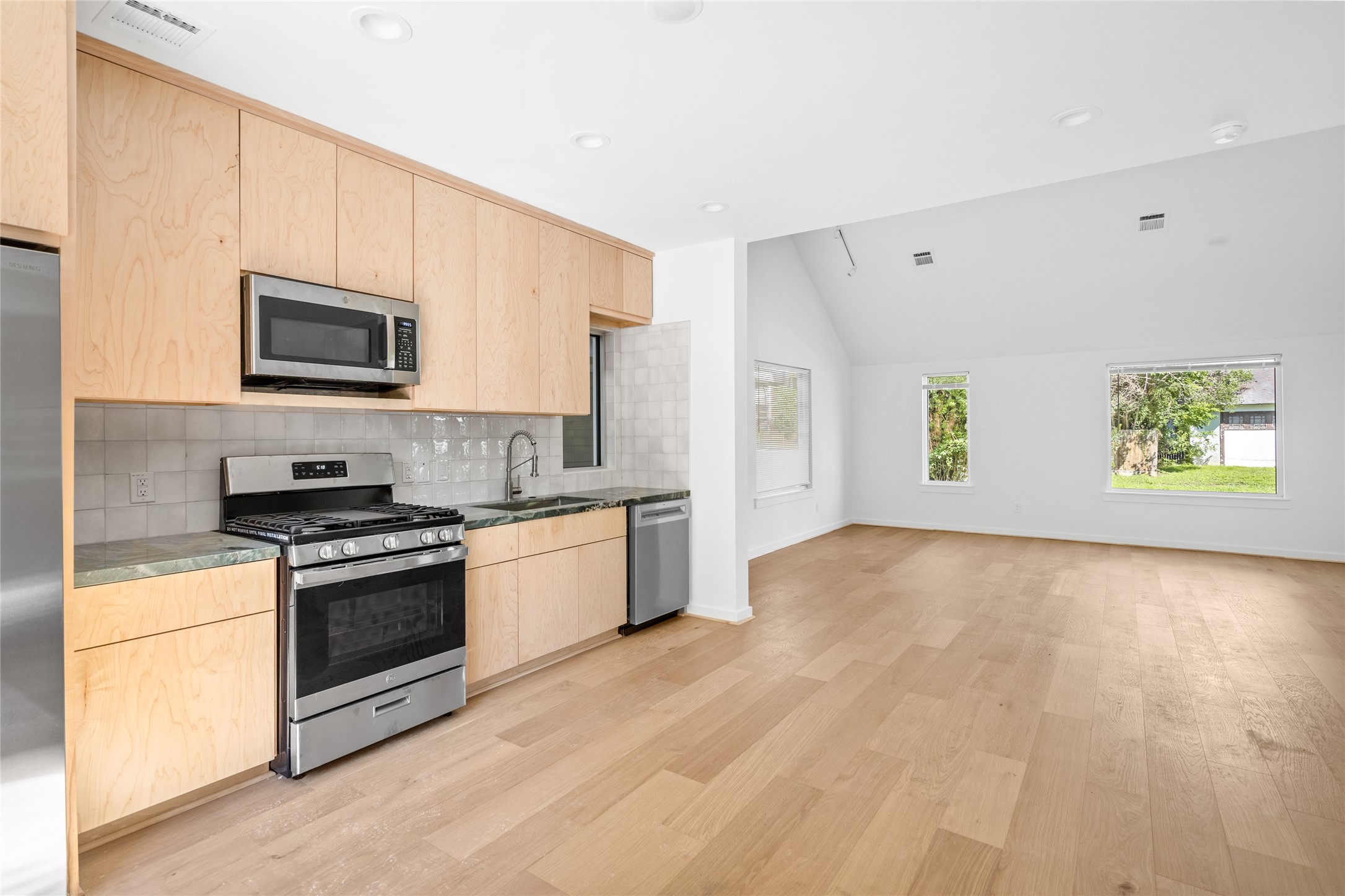 4429 Woodside Street, Unit B Houston, TX 77023 - Photo 11 of 17 a kitchen with a stove a microwave and window