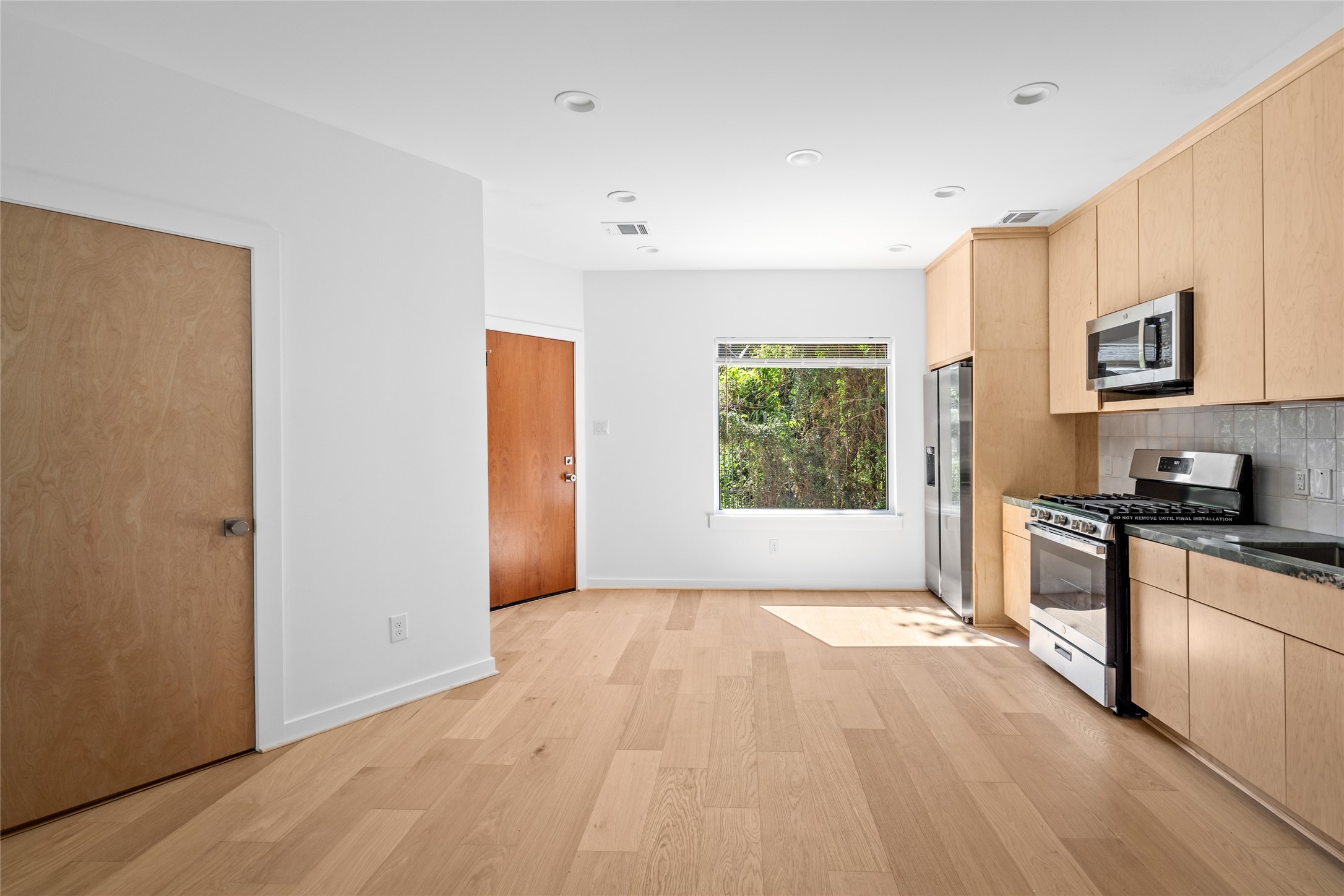 4429 Woodside Street, Unit B Houston, TX 77023 - Photo 8 of 17 a view of a kitchen with a sink dishwasher and wooden floor