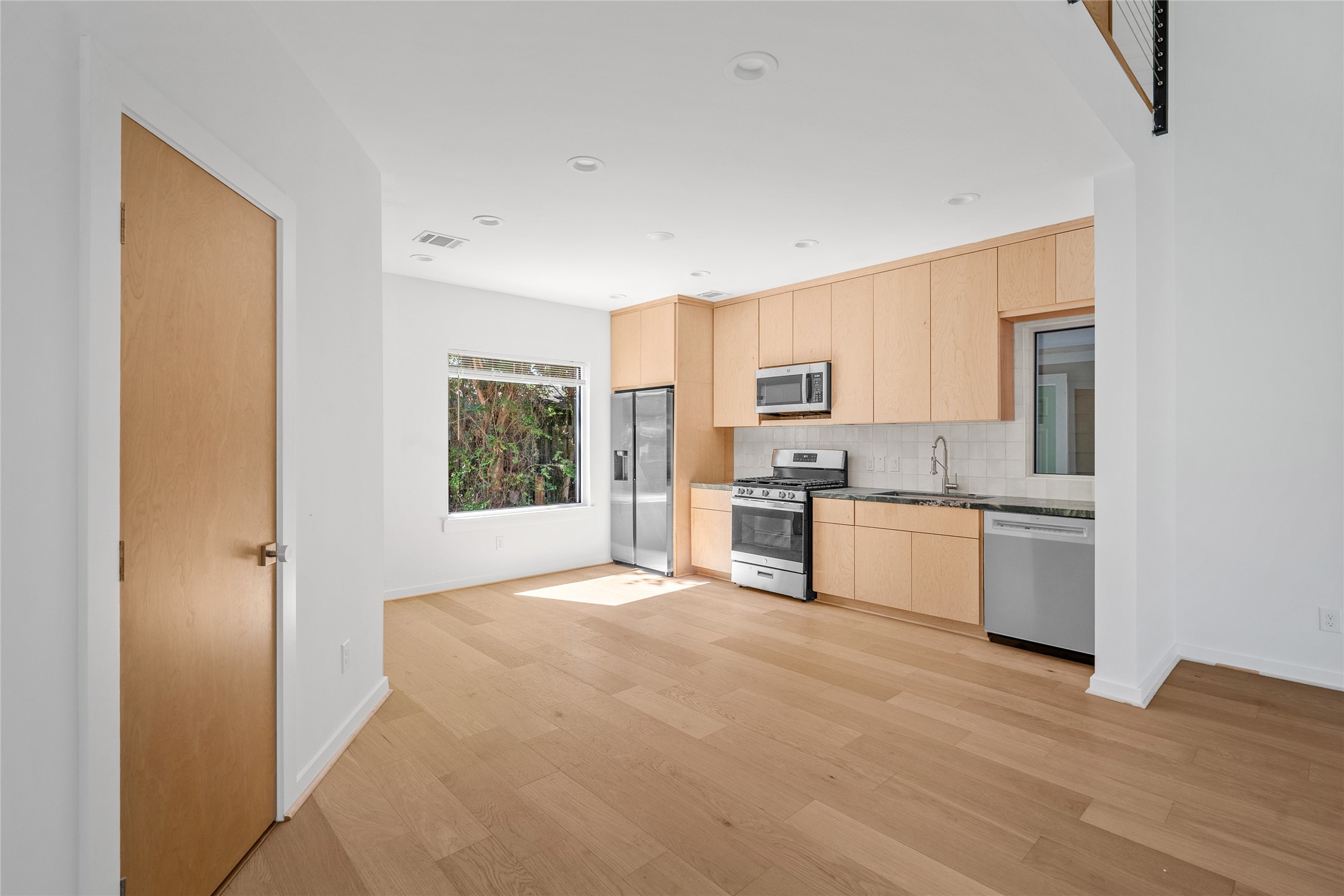 4429 Woodside Street, Unit B Houston, TX 77023 - Photo 9 of 17 a kitchen with stainless steel appliances granite countertop a refrigerator sink and cabinets