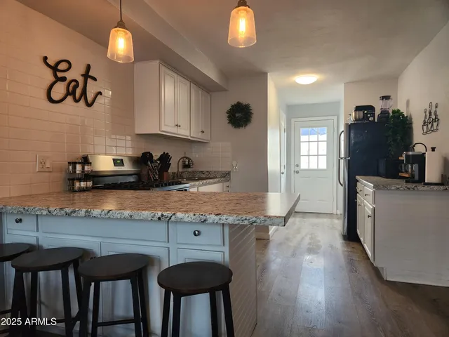 a kitchen with stainless steel appliances granite countertop a sink a stove and refrigerator